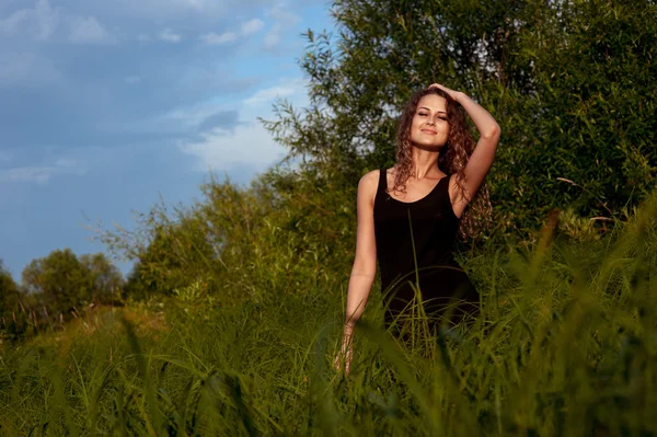 아름 다운 소녀는 높은 잔디에 걷는다 — 스톡 사진