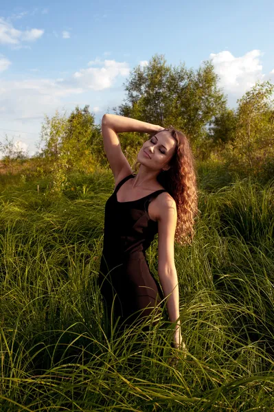 Hermosa chica camina en la hierba alta — Foto de Stock