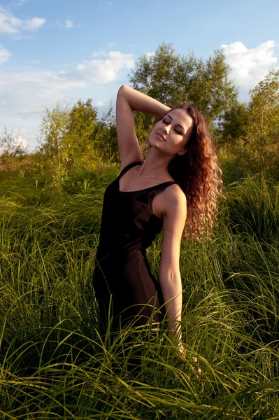 Beautiful girl walks in high grass — Stock Photo, Image