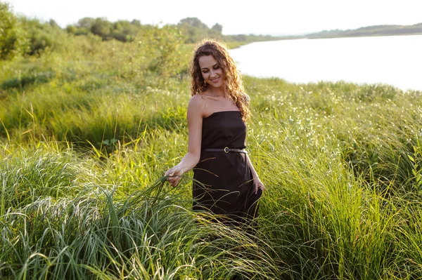 아름 다운 소녀는 높은 잔디에 걷는다 — 스톡 사진