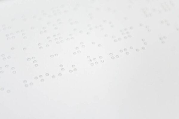 Фрагмент текста Луи Брайля, напечатанный на стандартном листе бумаги с использованием специального печатного оборудования.