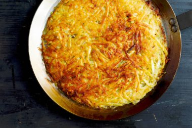 Bir tava altın isviçre rosti kızarmış patatesli krep.