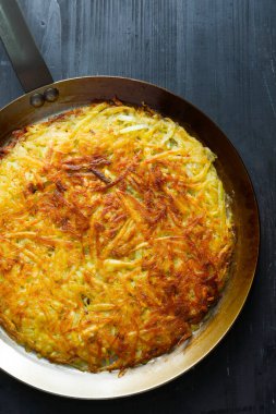 Bir tava altın isviçre rosti kızarmış patatesli krep.