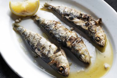 close up of plate of grilled sardines                              