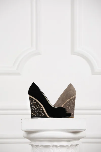 Beautiful female shoes on a white stand antique column. — Stock Photo, Image