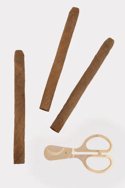 Three cigars and gold scissors — Stock Photo, Image