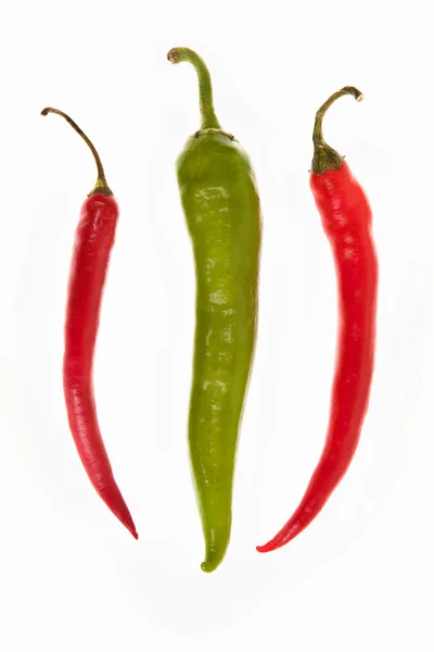 One green and two red peppers on a white background — Stock Photo, Image