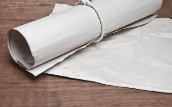 Древний свиток с бумагой на деревянном столе — стоковое фото