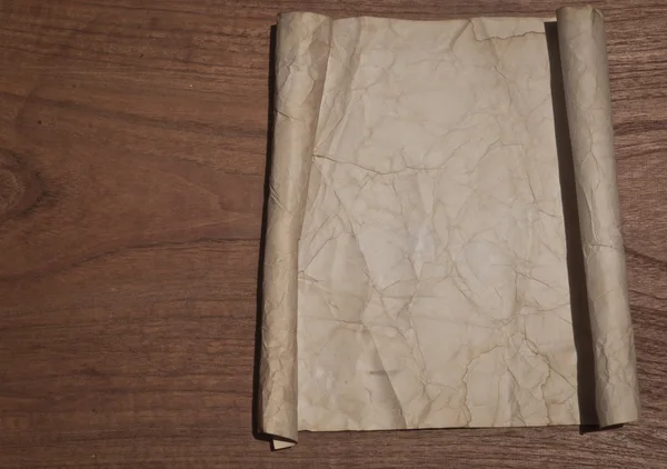 Αρχαία τσαλακωμένο χαρτί κύλισης στο τραπέζι από ξύλο για το φόντο — Φωτογραφία Αρχείου