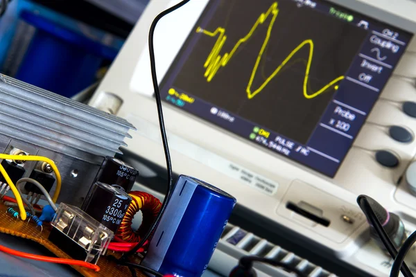 DC / DC converter and the switching waveform on the oscilloscope — Stock Photo, Image