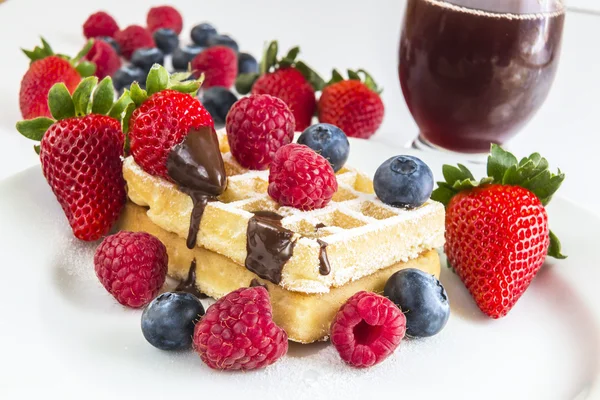 Ripe berry, some of on a waffle and behind white plate red fruit — Stock Photo, Image