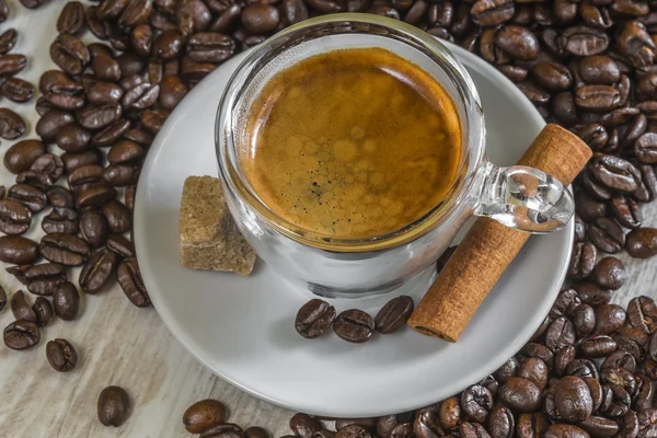 Fresh espresso coffee with sugar, cinnamon and lot of beans — Stock Photo, Image