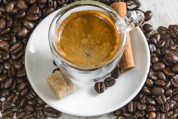 Crema on fresh espresso with sugar, cinnamon and coffee beans — Stock Photo, Image