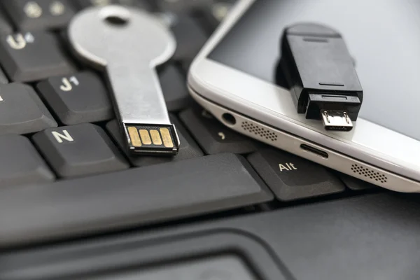 Klíč USB a smartphone s mikro usb flash disk v notebooku keyb — Stock fotografie