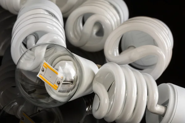 หลอดไฟ LED ระหว่างหลอด CFL หลายหลอด — ภาพถ่ายสต็อก