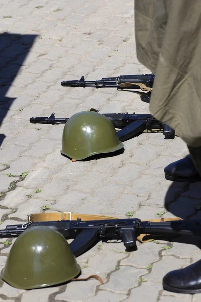 Helmets and assault rifles lay on the ground — Stock Photo, Image