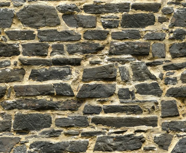 Textura de pared de piedra vieja de sillar negro sin costuras —  Fotos de Stock