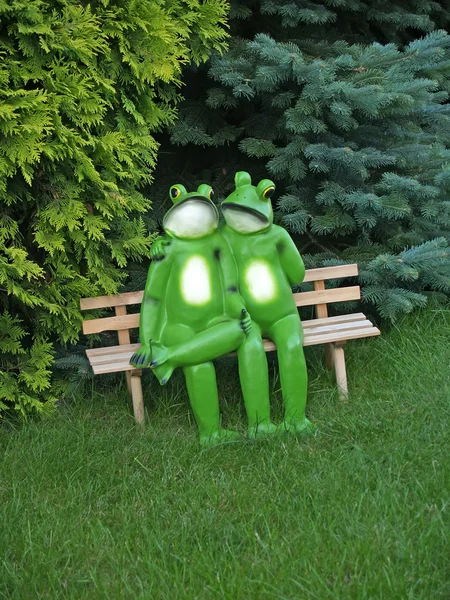 Enamoured frogs on a bench in park — Stock Photo, Image