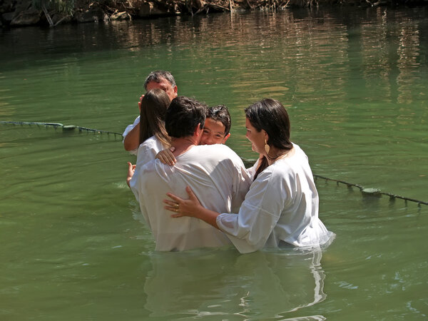Israel Happy family after a baptism of the child in holy waters of the Jordan River