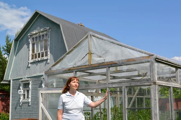 Die Frau mittleren Alters steht in der Nähe des Gewächshauses — Stockfoto