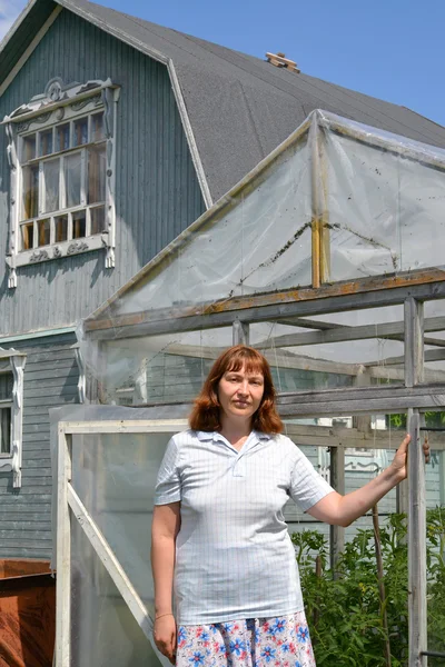 Kvinnan i genomsnitt år står nära växthuset — Stockfoto