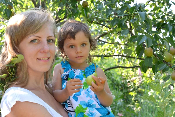 Ritratto della giovane donna con il bambino su un pero — Foto Stock