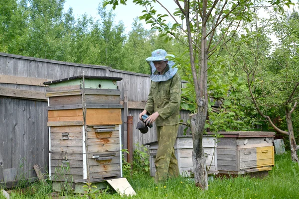 Le jeune apiculteur avec fumeur sur un rucher — Photo