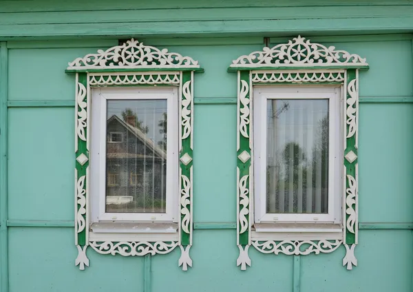 Two windows with carved platbands — Stock Photo, Image