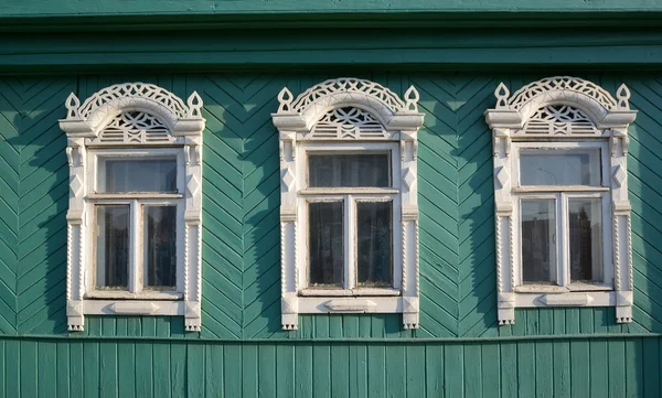 Three windows with white carved platbands — Stock Photo, Image