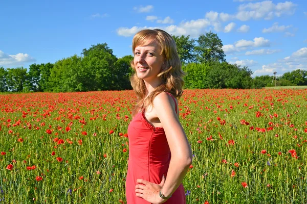 Portrait de la jeune femme dans un champ de pavot — Photo