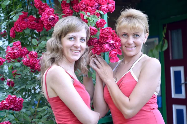 Dos mujeres jóvenes con rosas rojas —  Fotos de Stock