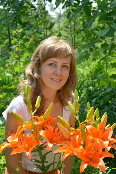 Портрет молодой женщины с оранжевыми лилиями — стоковое фото