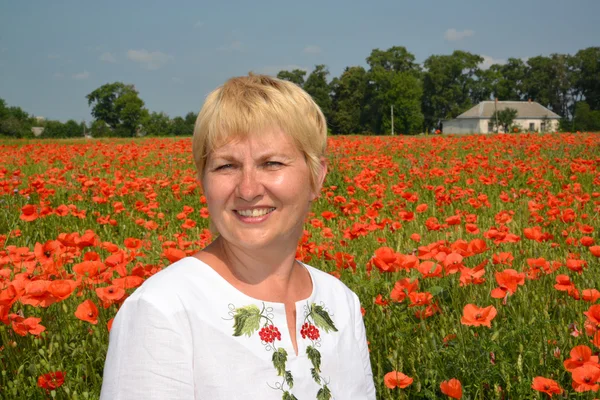 Portrait of the rural woman against a poppy field — Stock Photo, Image