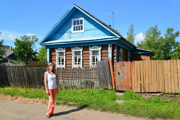 La joven se encuentra cerca de la casa rural de madera —  Fotos de Stock