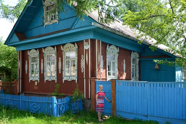 La femme ouvre une porte sur une cour de la maison en bois — Photo