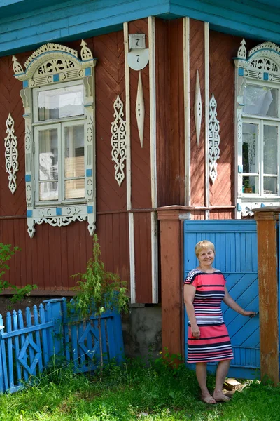 kadın Ahşap evin bahçesinde bir kapı açar.