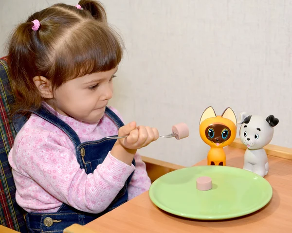 Het kleine meisje speelt voedsel tijd — Stockfoto