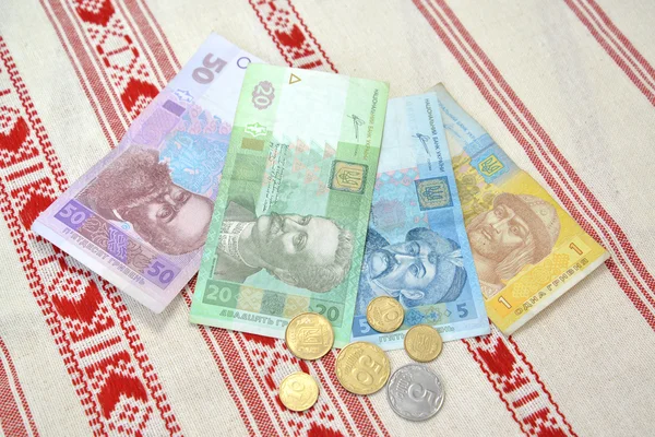 O dinheiro ucraniano contra a toalha bordada — Fotografia de Stock