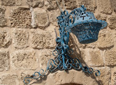 taştan bir duvar üzerinde dekoratif lamba. İsrail, yaffo
