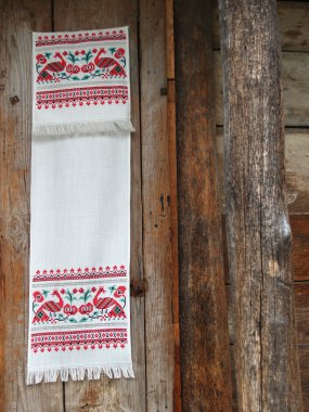 Ukraynalı havlu eski ahşap evin duvarında asılı