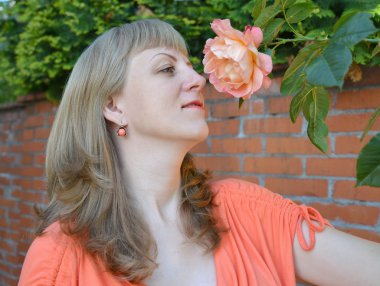 genç kadın bir gülü takdir ediyor.