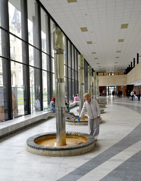 Femeia adună apă dintr-o sursă minerală din Karlovy Vary. C — Fotografie, imagine de stoc