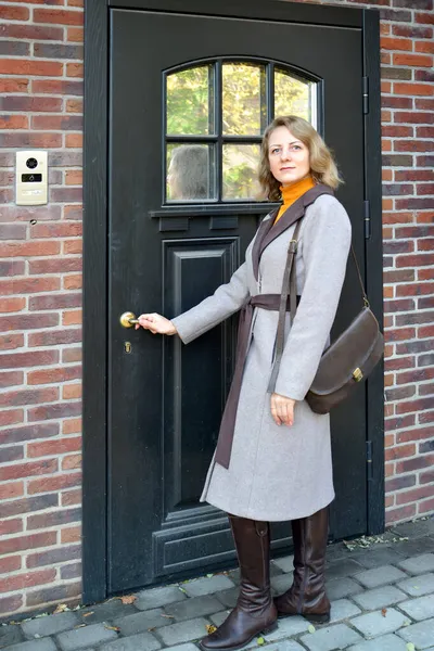 Uma Mulher Casaco Segura Maçaneta Porta Frente — Fotografia de Stock