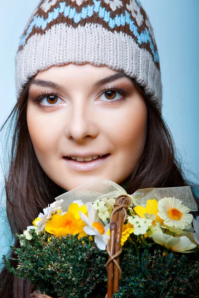 Smiling woman in cap with basket of flowers — Stock Photo, Image