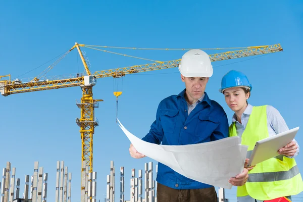 Polier und Ingenieur mit Bauplänen — Stockfoto