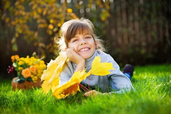 Ребенок с кленовыми листьями — стоковое фото