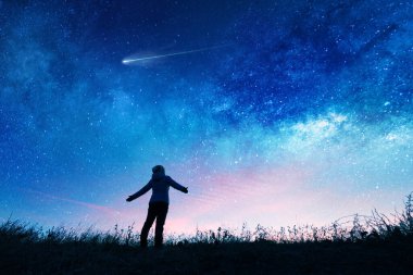 Gece gökyüzündeki yıldızları izleyen bir kız silueti