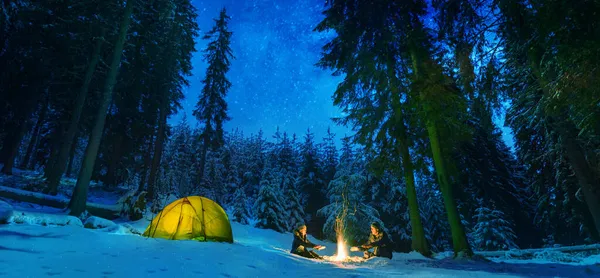 在冬天的森林里 有篝火和帐篷的夫妇在户外露营 — 图库照片