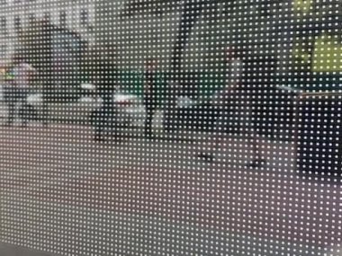 Büyük bir nokta deseninden oluşan soyut bir arkaplan. Görüntü kendiliğinden ve kaotik bir şekilde değişir. İnsanlar arkadan yürüyor. Video.