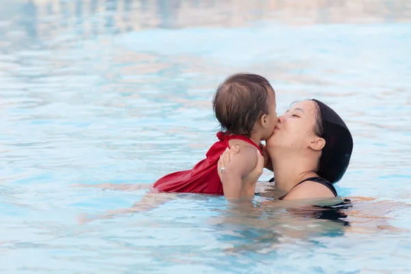 亲吻她的女儿在泳池中的母亲 — 图库照片